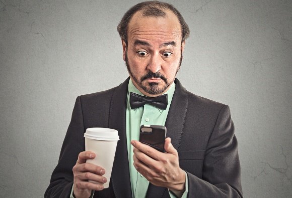 Businessman Drinking Coffee Looking at Phone