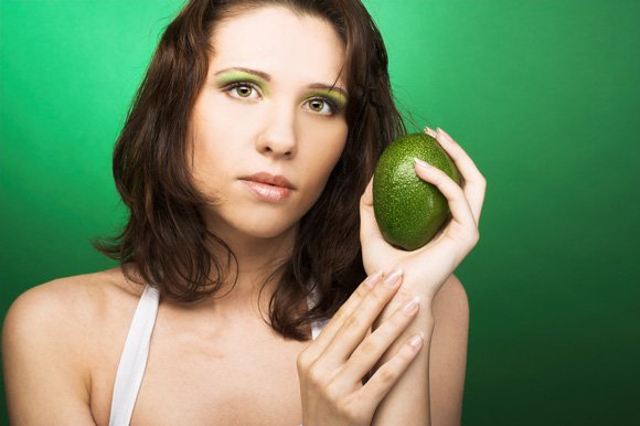 Woman Holding a Green Avocado